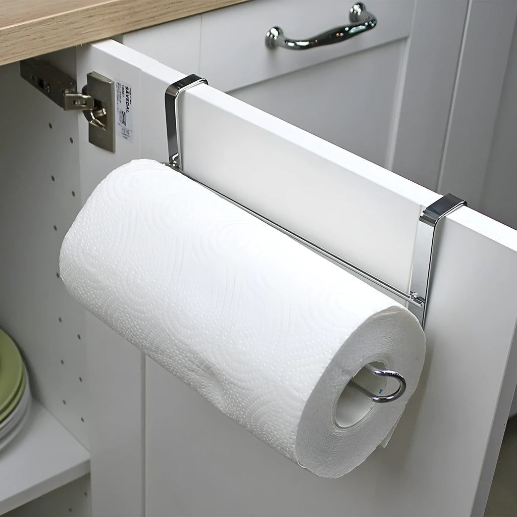 Silver stainless steel paper towel rack hanging on the back of a kitchen cabinet door.