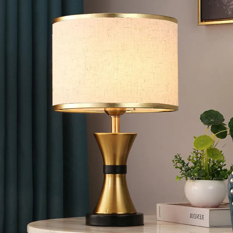 Simple bedroom table lamp with iron body and fabric shade in black finish on wooden desk