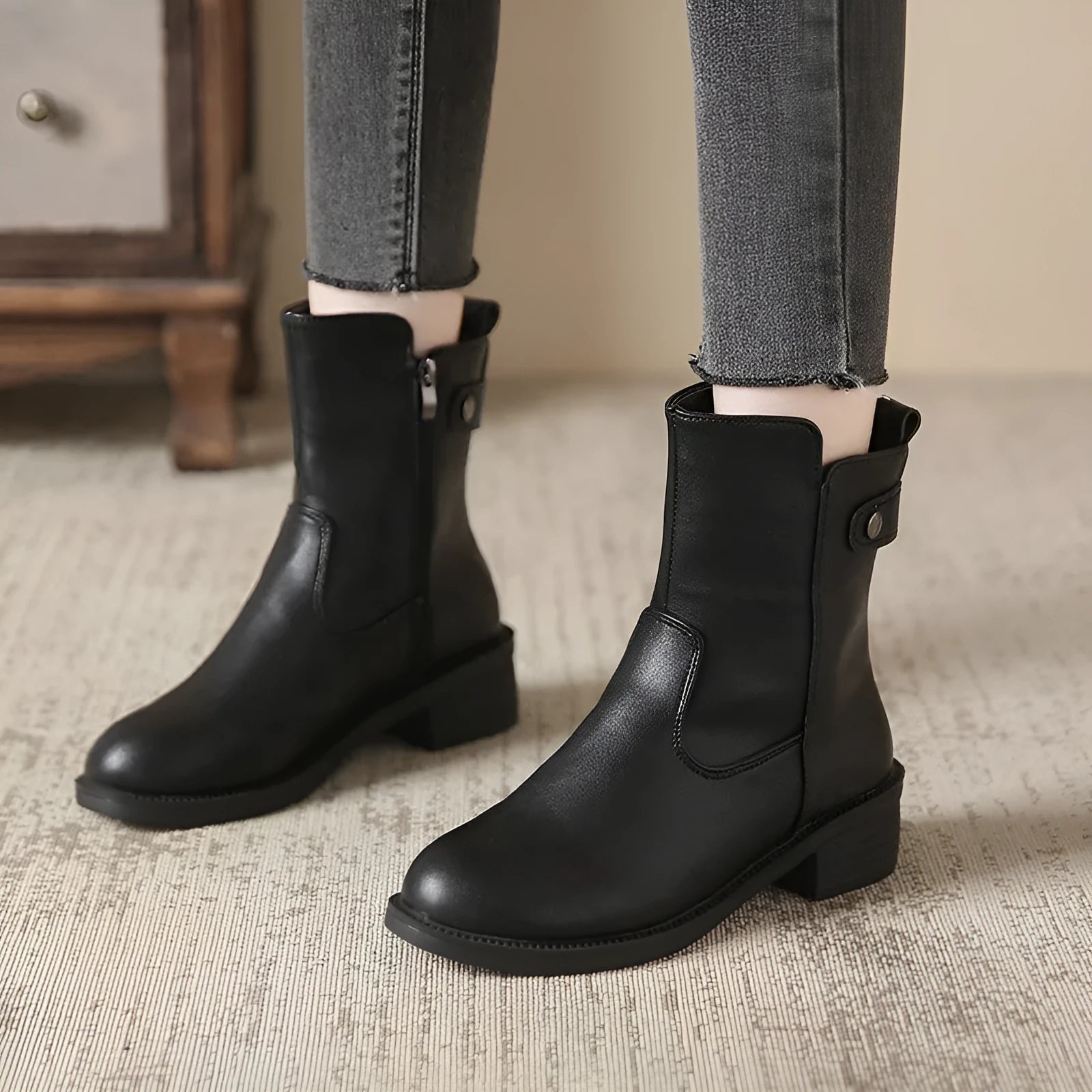 Black women's ankle boots with side zip, round toe, and low rubber sole