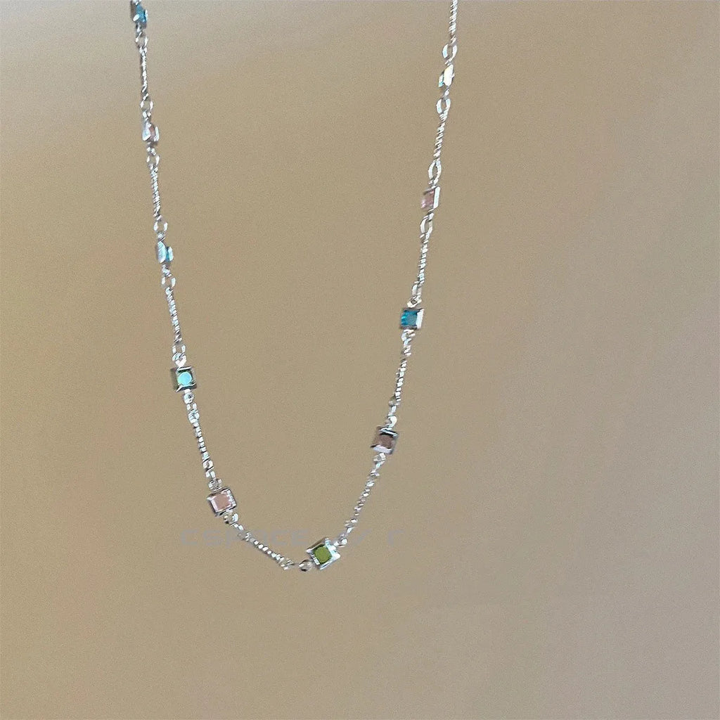Square colour geometric quadrilateral alloy clavicle chain necklace with artificial crystal details on a model.