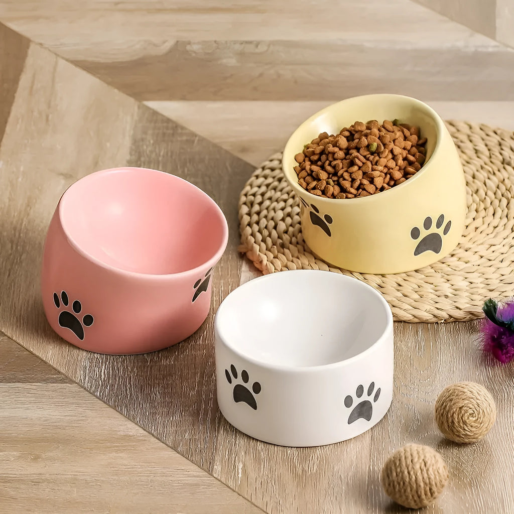 Ceramic cat bowl with oblique mouth and high foot, available in cat's paw colours pink, yellow, black, white