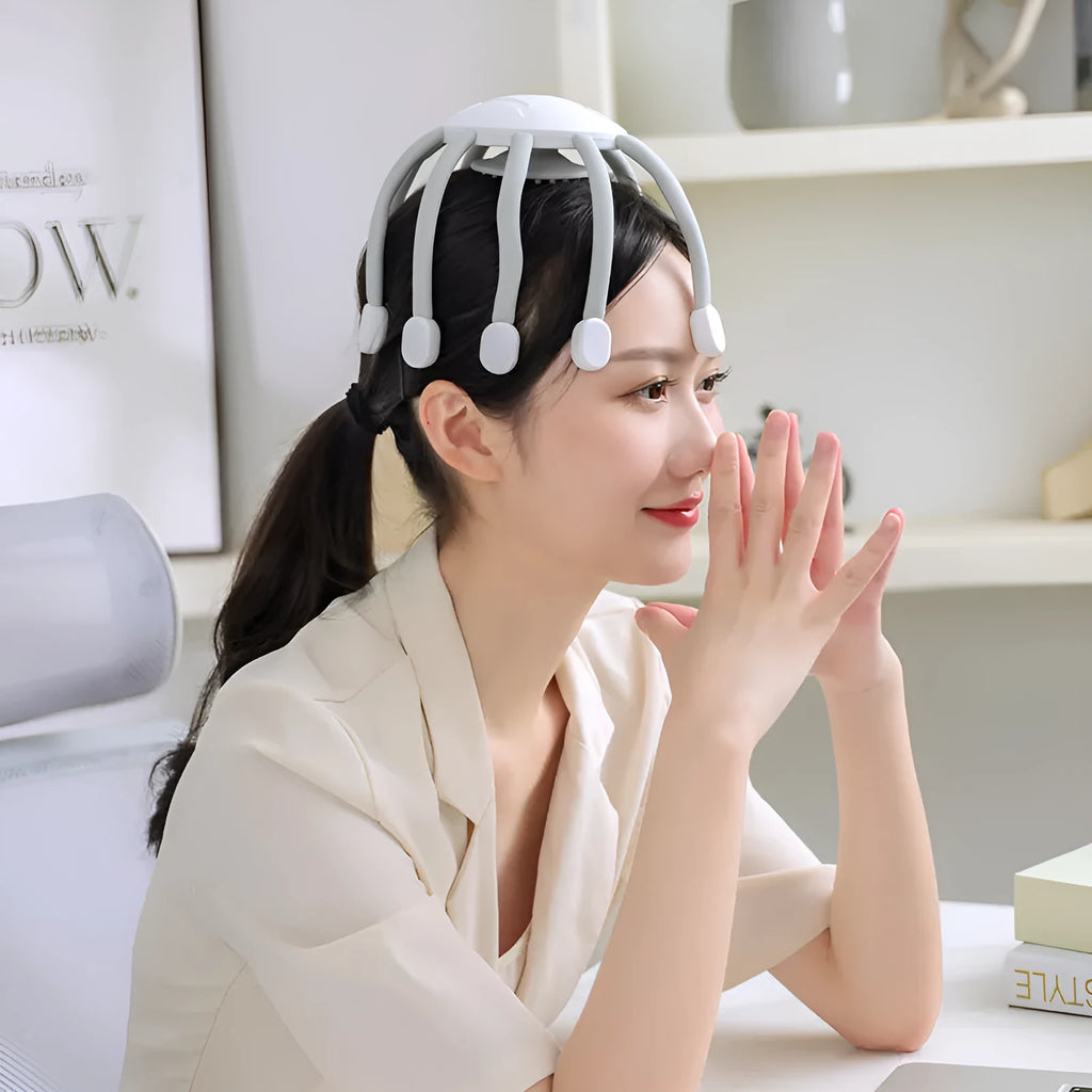 Black handheld electric scalp massager with multiple flexible silicone claws vibrating on a scalp.