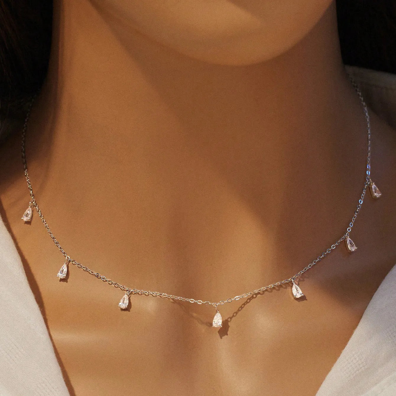 Silver drop-shaped artificial zircon necklace on an O-chain with triangular detail, showing rose gold and golden yellow colour options.