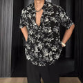 Loose fit black floral print short sleeve casual shirt on a hanger