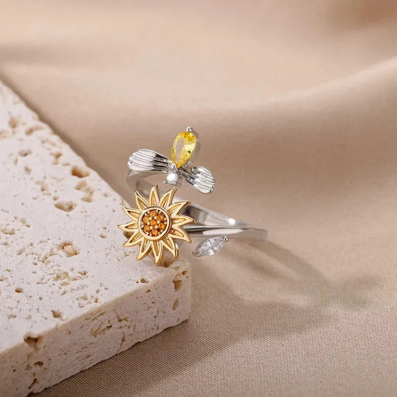 Simple gold adjustable spinner ring with rotating geometric component on a finger.