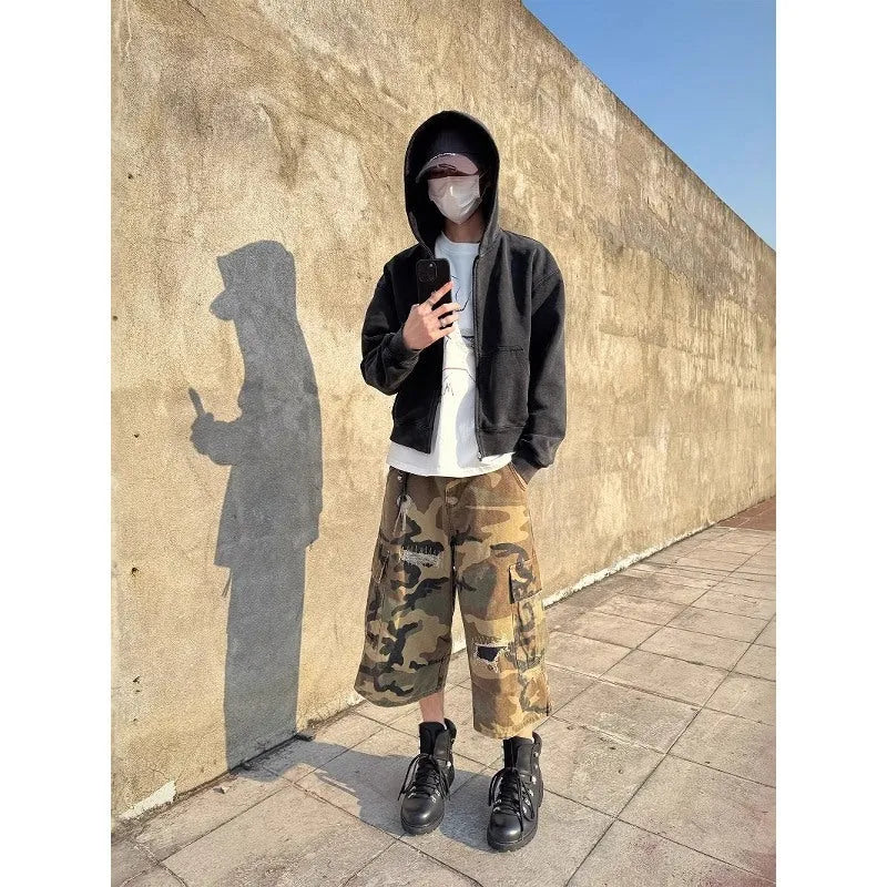 Men's loose-fit camouflage cropped jeans with ripped knees and retro patches on a straight-leg.
