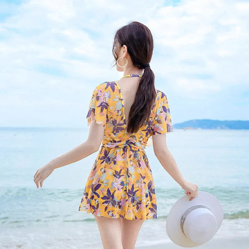 Women's yellow floral one-piece swimsuit with attached skirt, made from polyester, available in multiple sizes