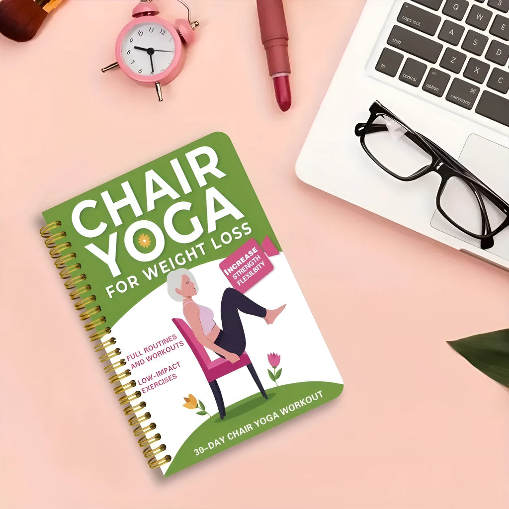 Green coil-bound 30-day chair yoga training guide notebook with calendar layout on a desk