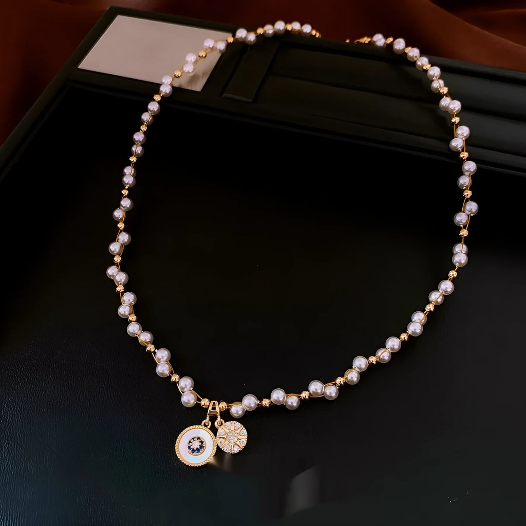 Gold electroplated necklace with round imitation pearl pendant and zircon accents on clavicle-length chain