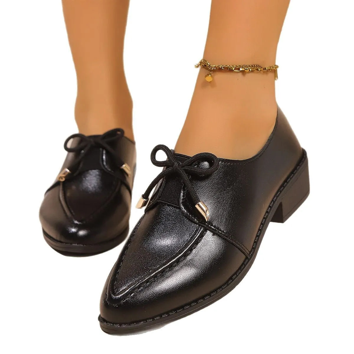 Women's leather-look slip-on shoes with decorative bow buckle detail and pointed toe