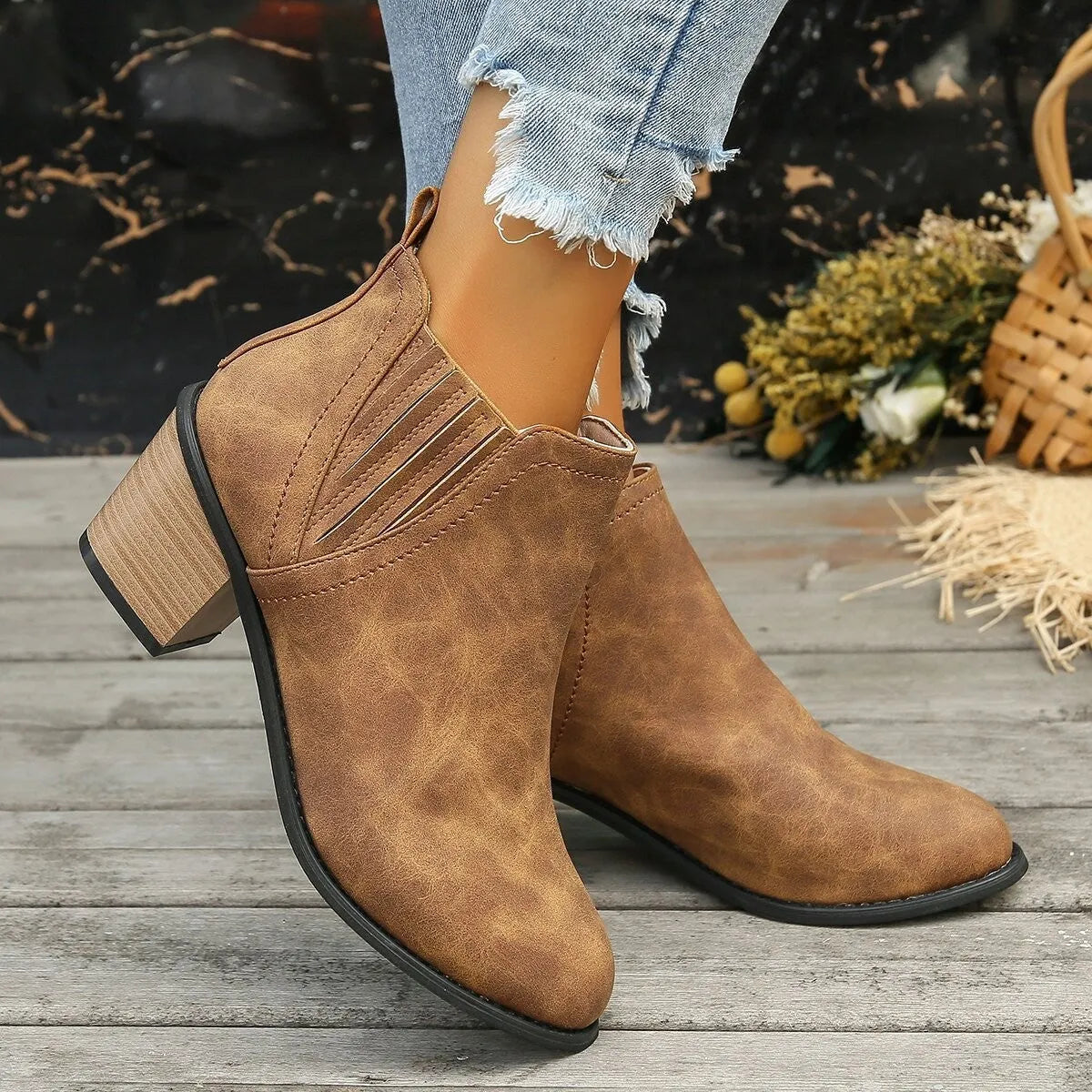 Black women's pointed toe ankle boots with a thick square low heel and slip-on design.
