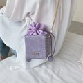 Small women's messenger bag with chain strap in six colour options showing bucket shape and zip opening