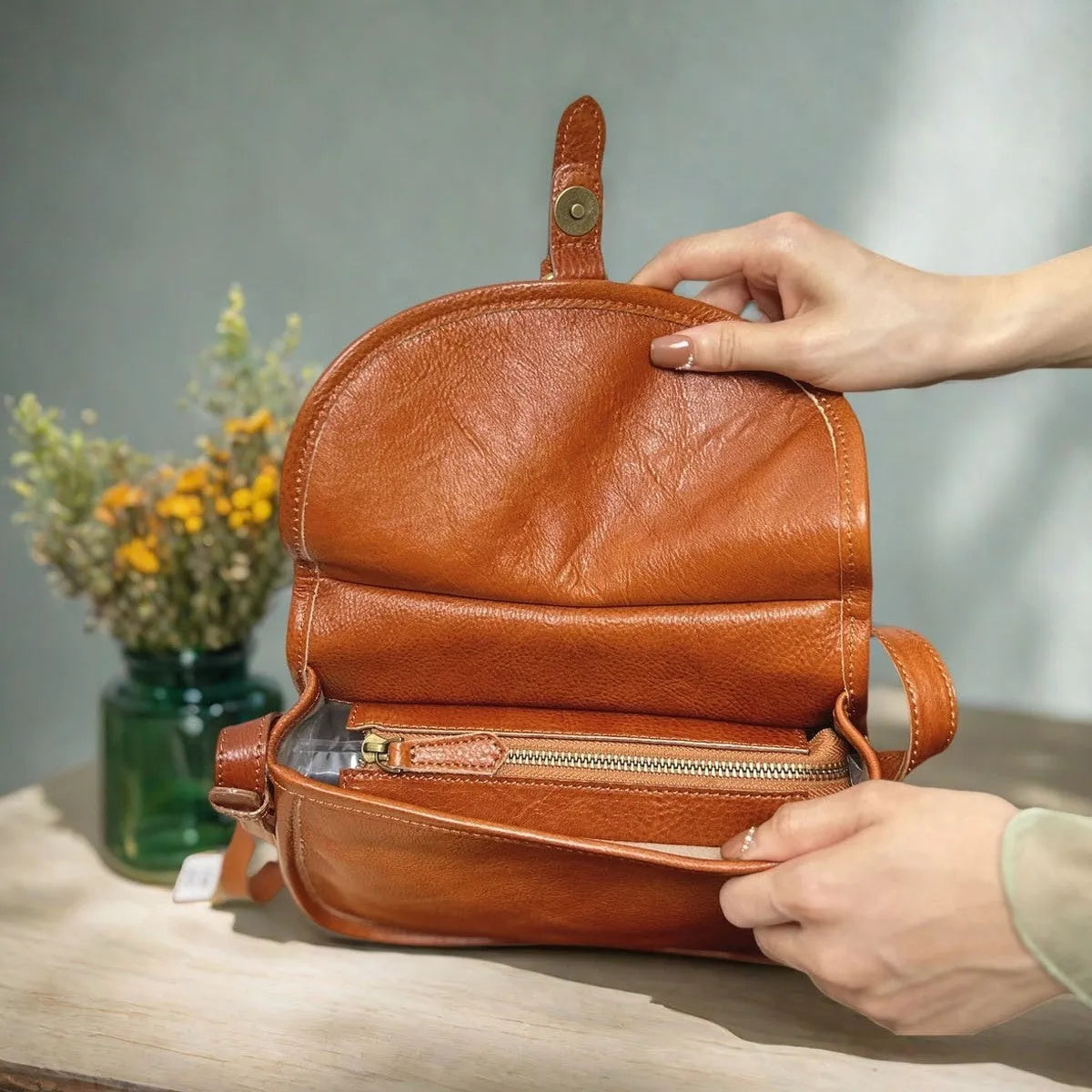 Genuine leather messenger bag with shell shape and sewing line detail in brown