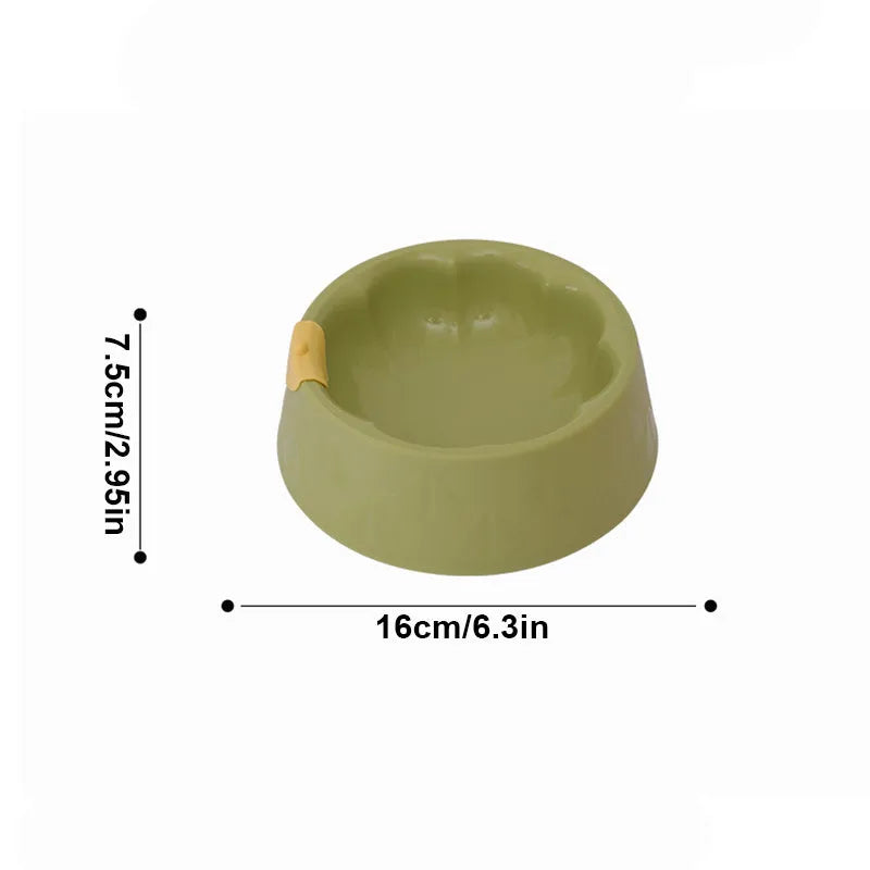 Green and yellow plastic double pet bowl for food and water on a flat surface.