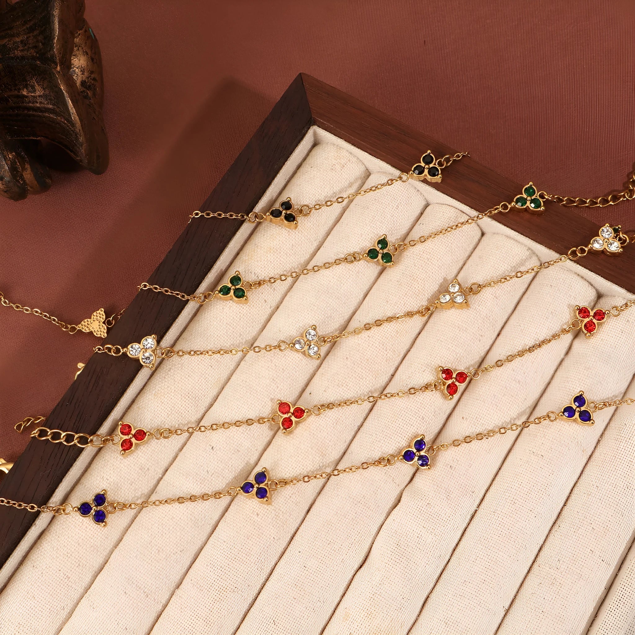 Geometric stainless steel women's bracelet with three diamond shapes and coloured stone settings.