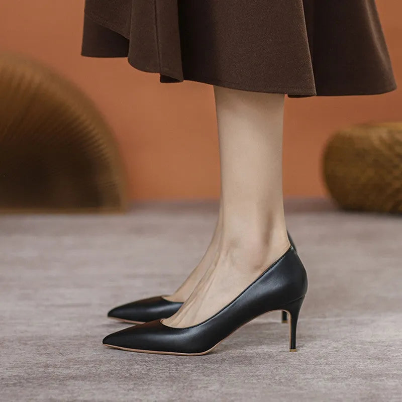 Black pointed high heel shoes with stiletto heel and microfiber upper on a white background