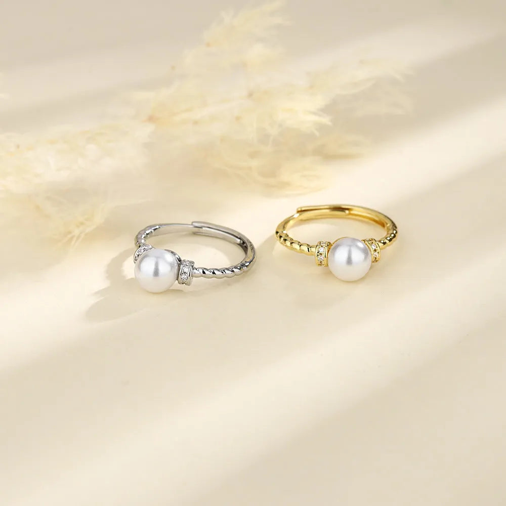 Adjustable antique-style copper ring with a geometric shape and an inlaid pearl, shown in gold and silver colour options.