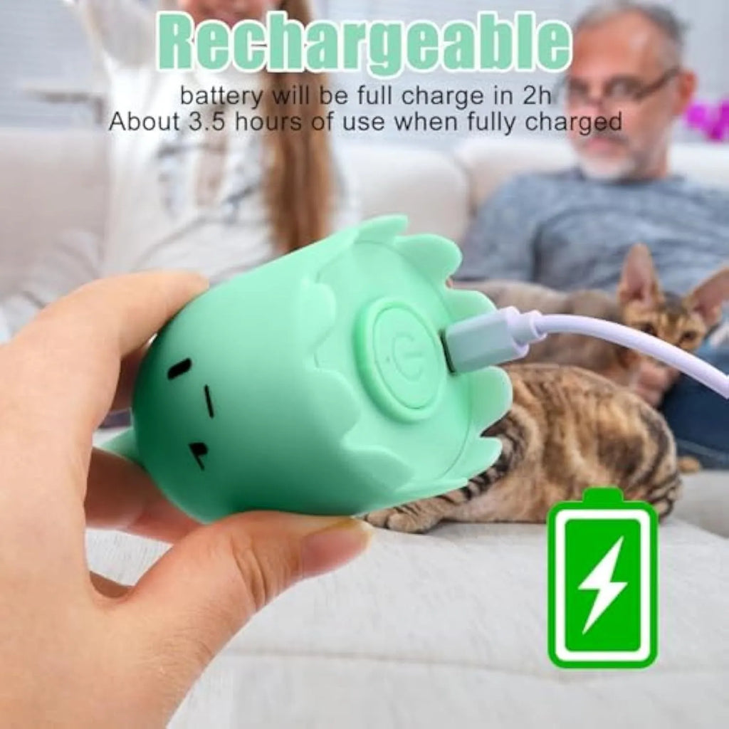 Green automatic electronic cat wand toy with a swinging silicone tail on a wooden floor.