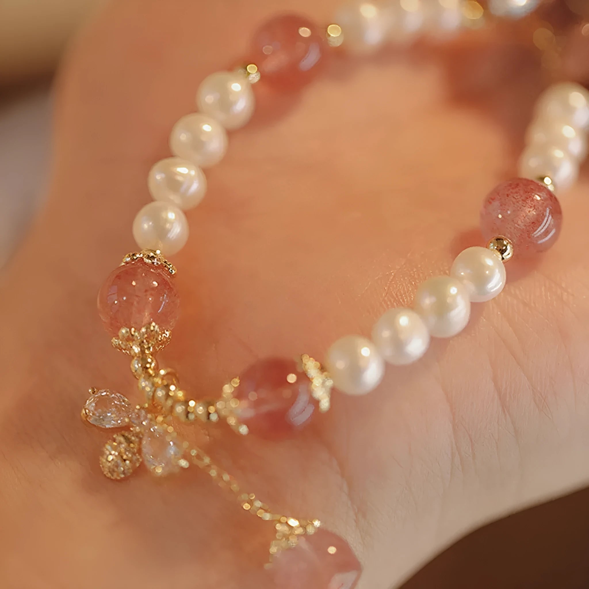 Crystal strawberry quartz bracelet with bow detail on white background, women's INS-style accessory