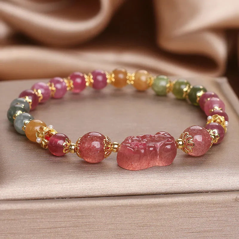 Pink crystal Pi Xiu bracelet with tourmaline and strawberry quartz beads on white background