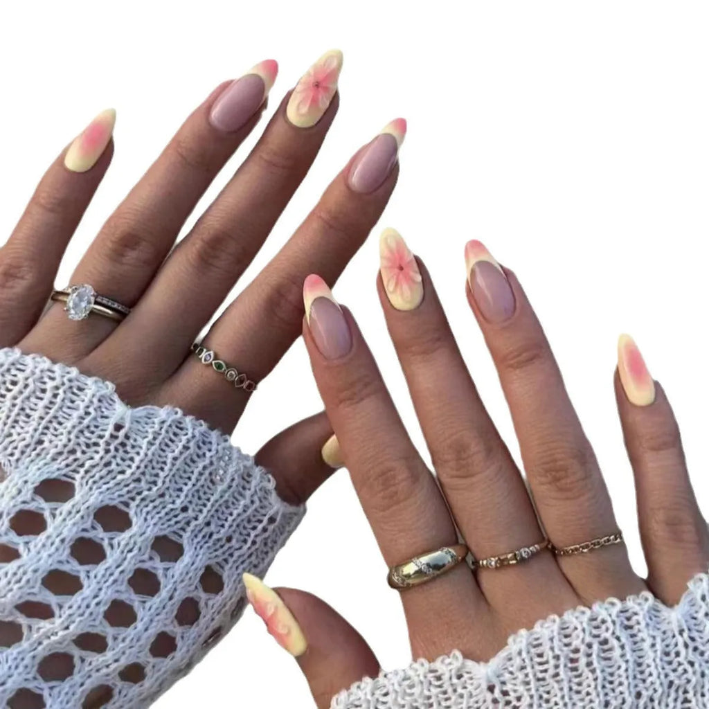 Detachable fake nails with pink 3D cartoon flowers, jelly glue, and filing strip on white background