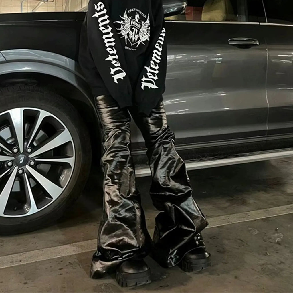Black shiny patent leather straight-leg skinny jeans on a hanger
