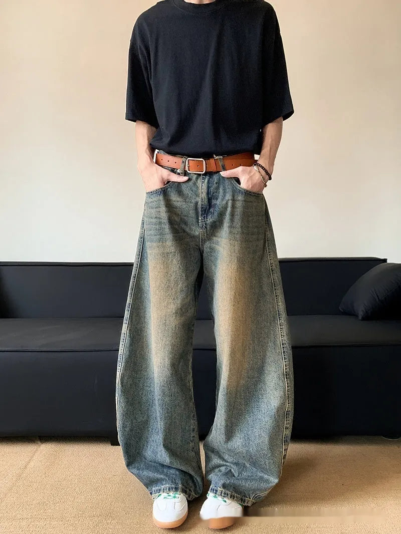 Man wearing retro blue distressed denim wide-leg trousers with a slim fit and zipper fly