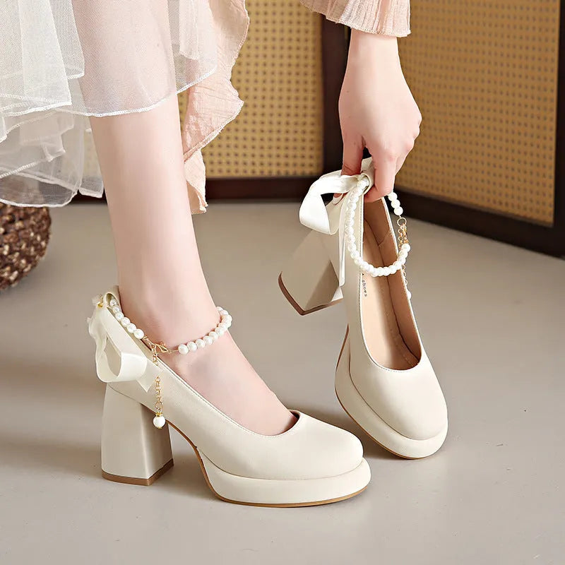 Beige women's Mary Jane shoes with chunky heel, ankle strap buckle, and pearl decoration on round toe
