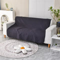 Reversible dog blanket on sofa showing two colour sides, protecting furniture from pets