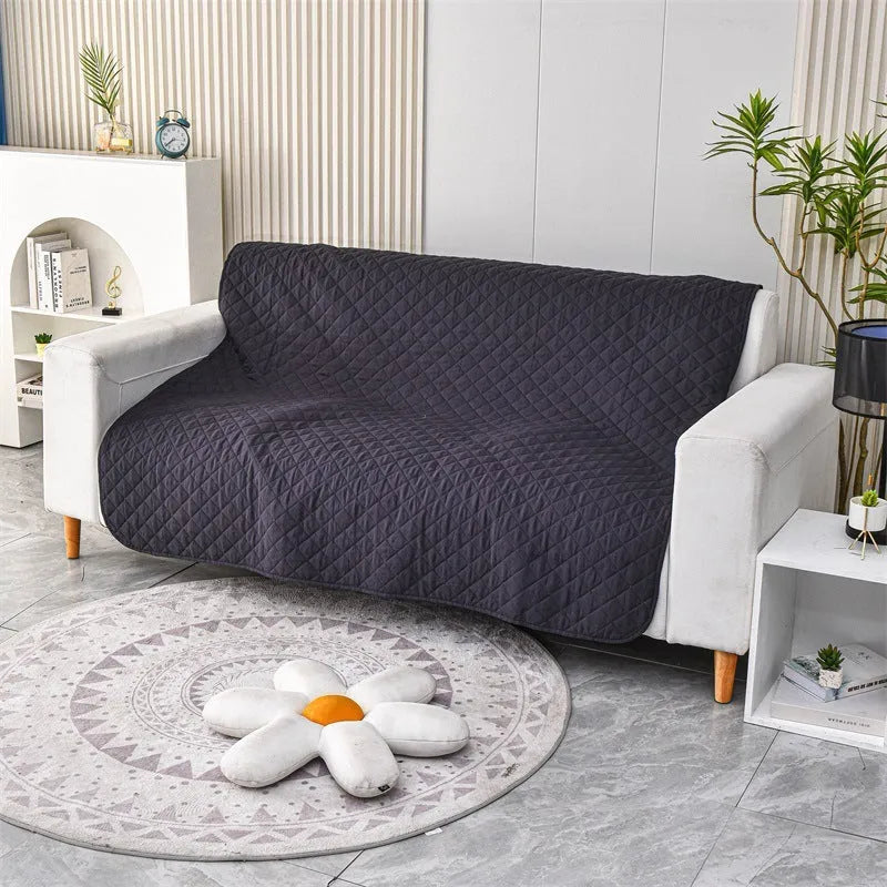 Reversible dog blanket on sofa showing two colour sides, protecting furniture from pets