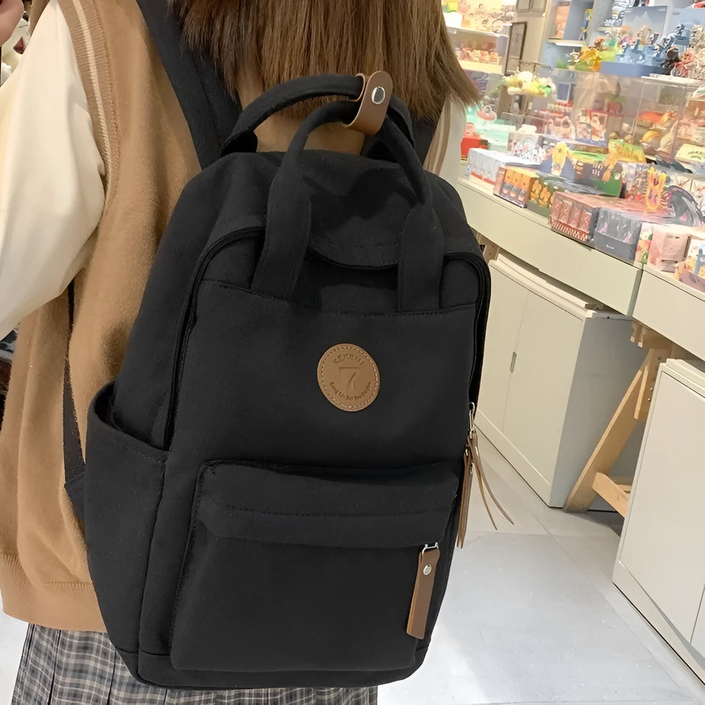 Black Oxford cloth leisure backpack with curved shoulder straps showing retro sewing thread details