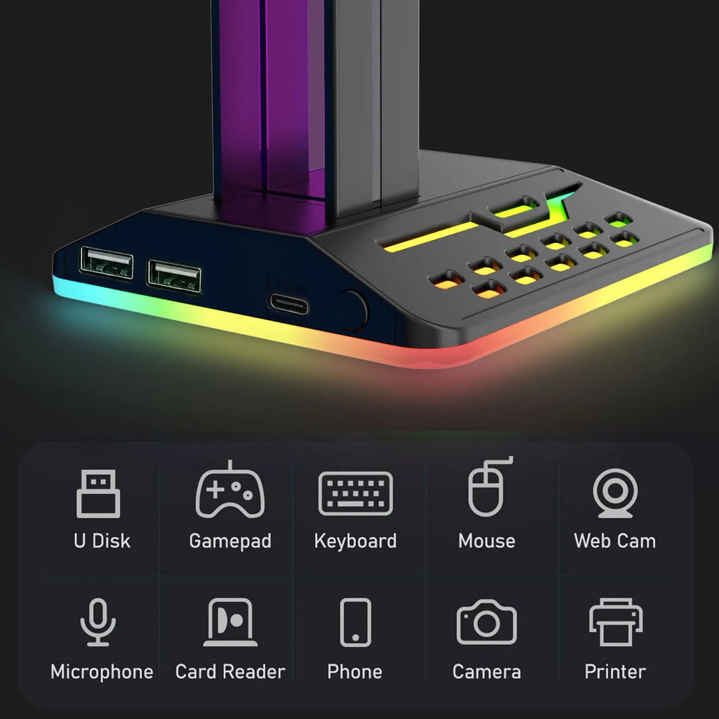 RGB colour changing headphone stand with dual USB ports on a desk next to a gaming headset.