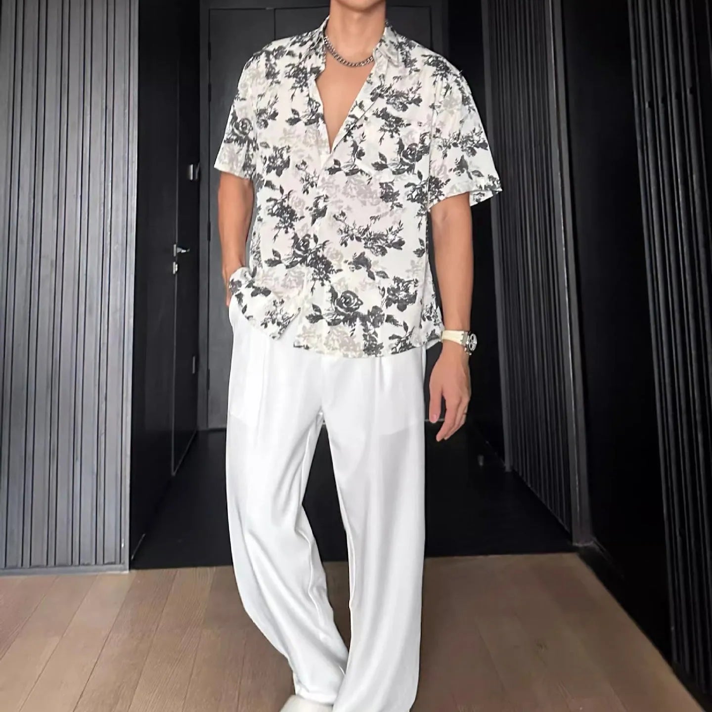 Loose fit black floral print short sleeve casual shirt on a hanger