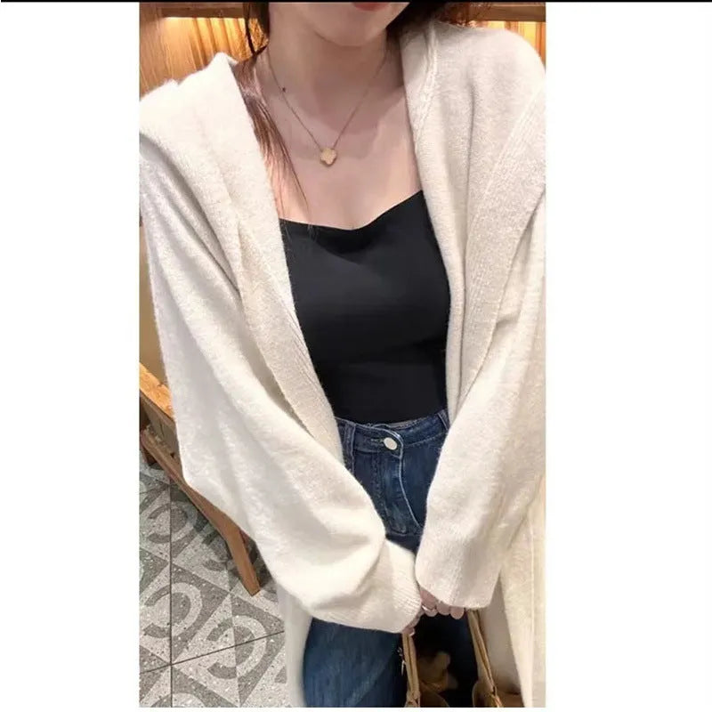 Woman wearing a long, loose, hooded knitted cardigan in a neutral colour, Korean casual style.