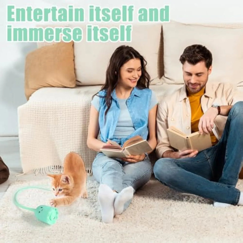 Green automatic electronic cat wand toy with a swinging silicone tail on a wooden floor.