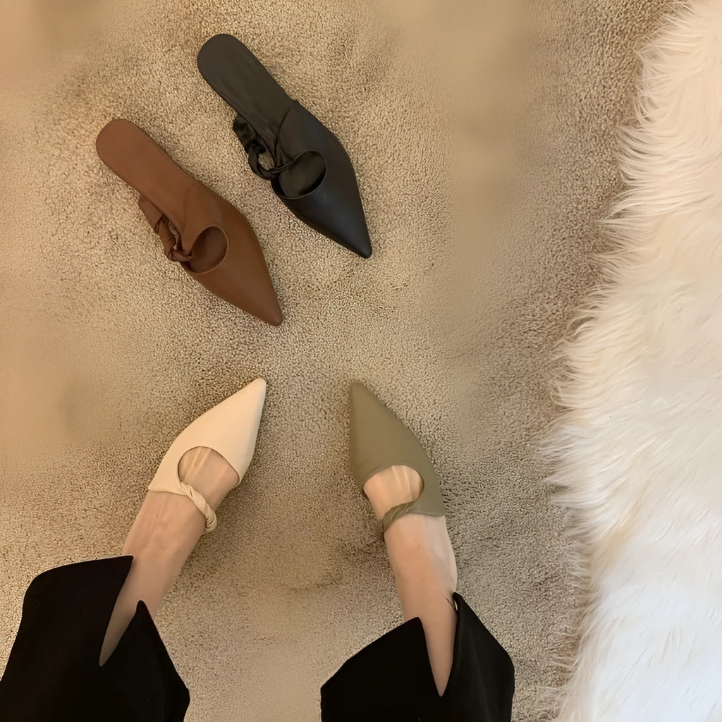 Women's soft leather semi-toe box slippers in black with rubber sole, side view.