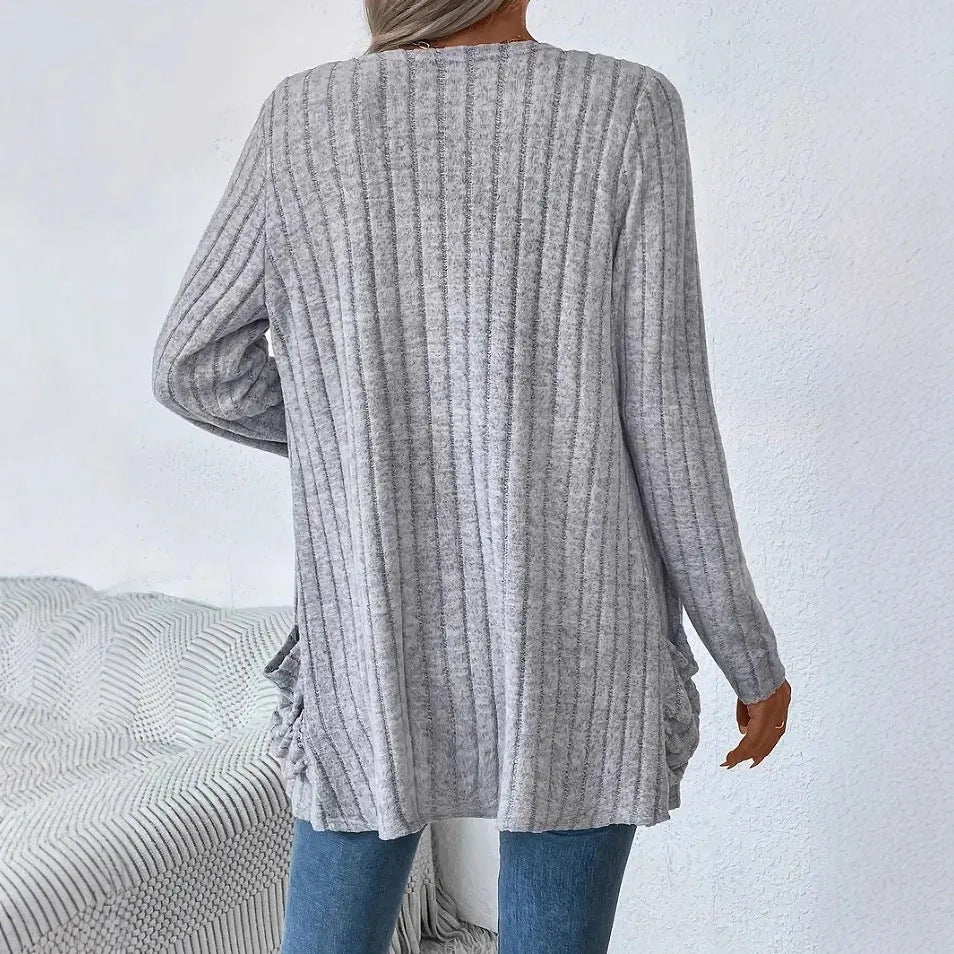 Man wearing a solid grey loose-fit long sleeve cardigan with side pockets.