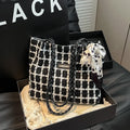 Black woven wool shoulder bag with horizontal square shape showing internal organiser compartments