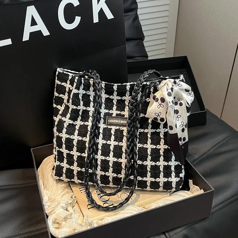 Black woven wool shoulder bag with horizontal square shape showing internal organiser compartments