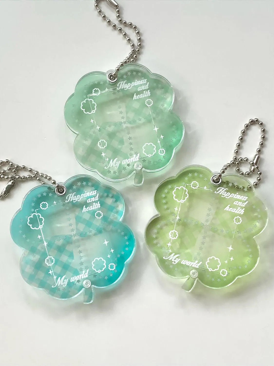Four-leaf clover shaped acrylic pendant keychain in mint green colour on a surface