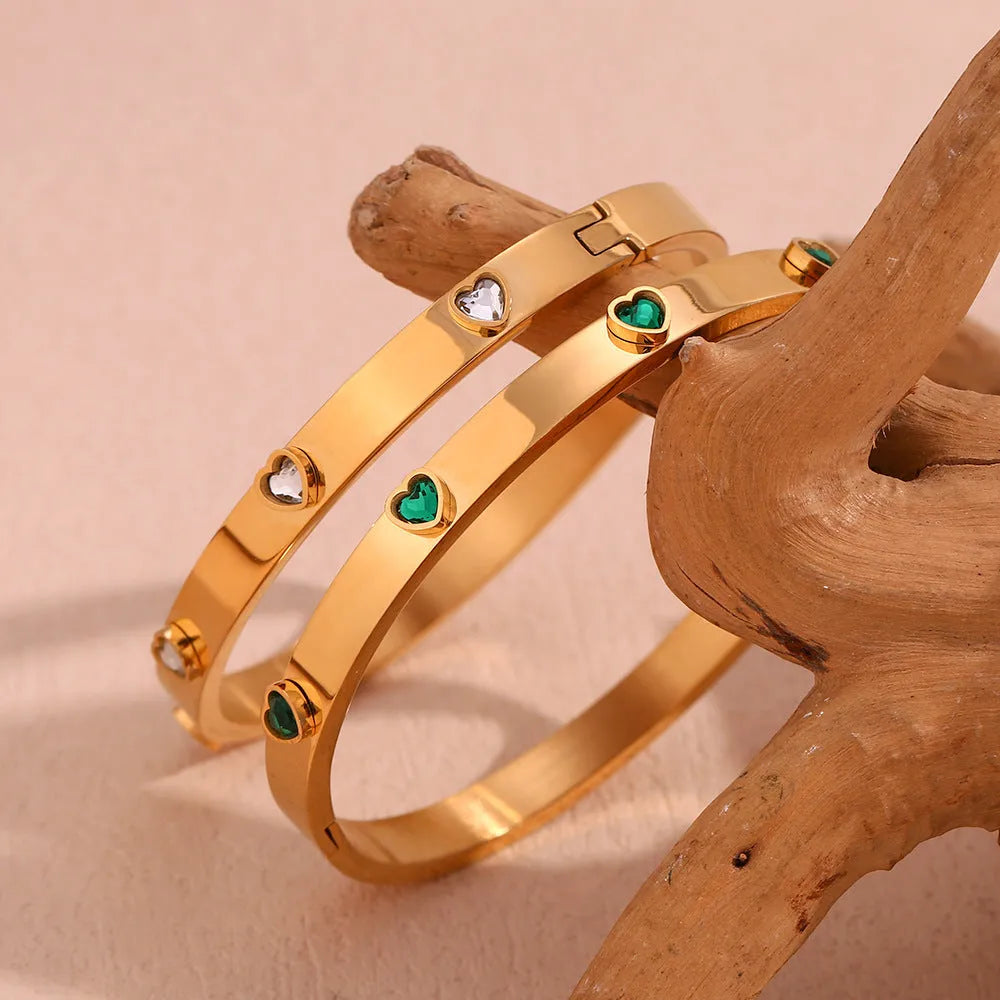 Women's stainless steel bracelet with a micro-inlaid peach heart charm in a golden electroplated colour.