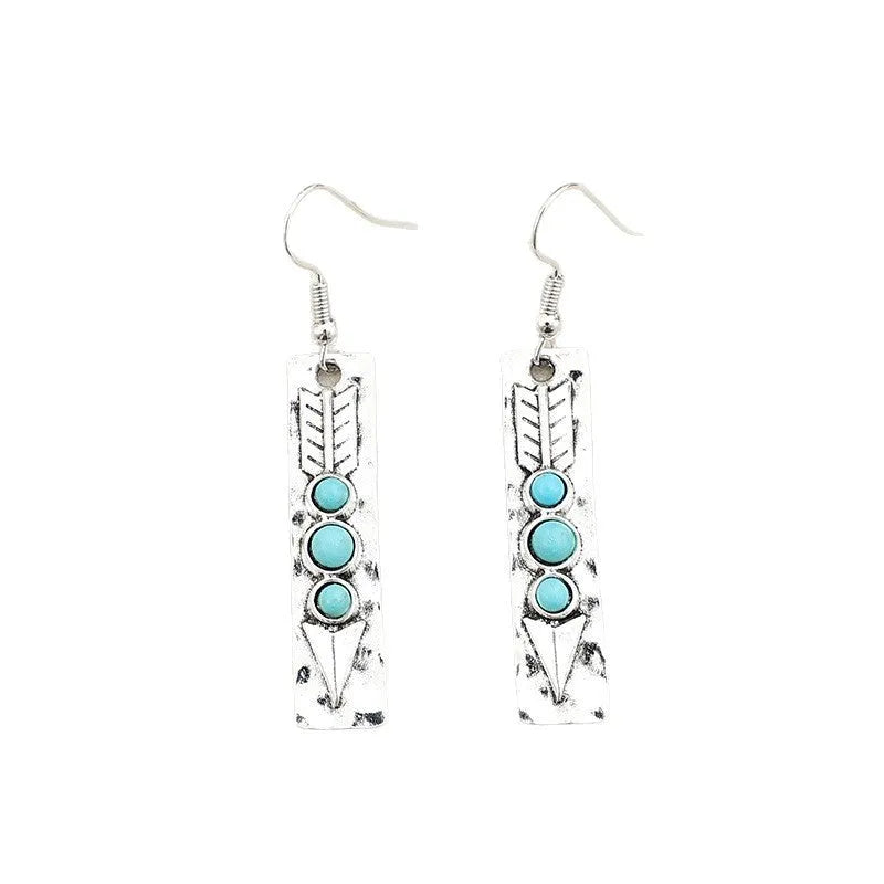 Long strip geometric silver earrings with inlaid turquoise detail on a white background