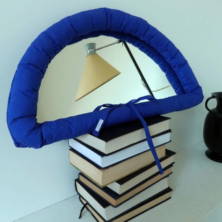 Soft cotton-filled fabric mirror in solid colour hanging as a background prop