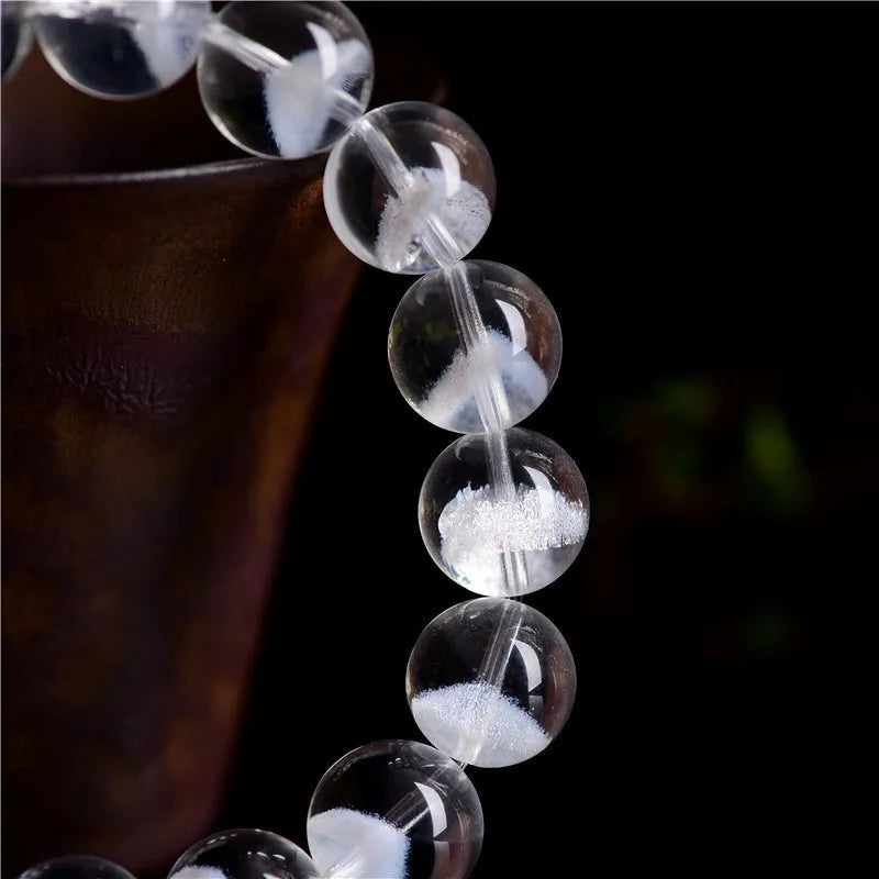 Women's natural white ghost pyramid crystal bracelet showing textured surfaces and ruyi charm detail