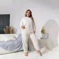 Women's creamy white polyester two-piece suit with crew neck top and matching trousers
