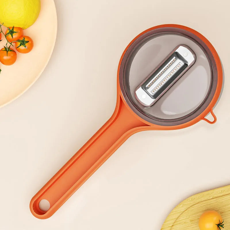 Kitchen multi-functional peeler with bucket storage in light green and orange colours, food-grade plastic construction