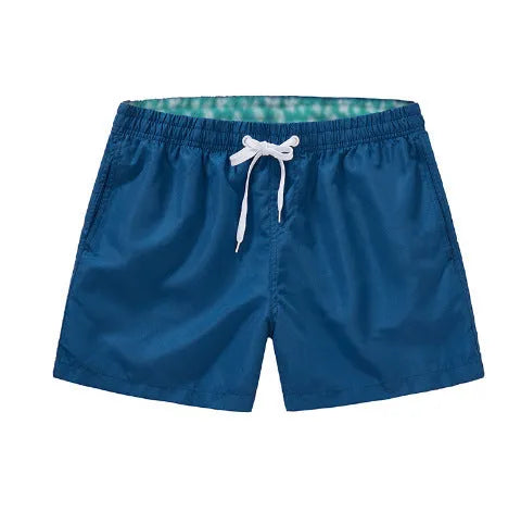 Men's straight-leg beach shorts in black polyester fabric on a size chart.