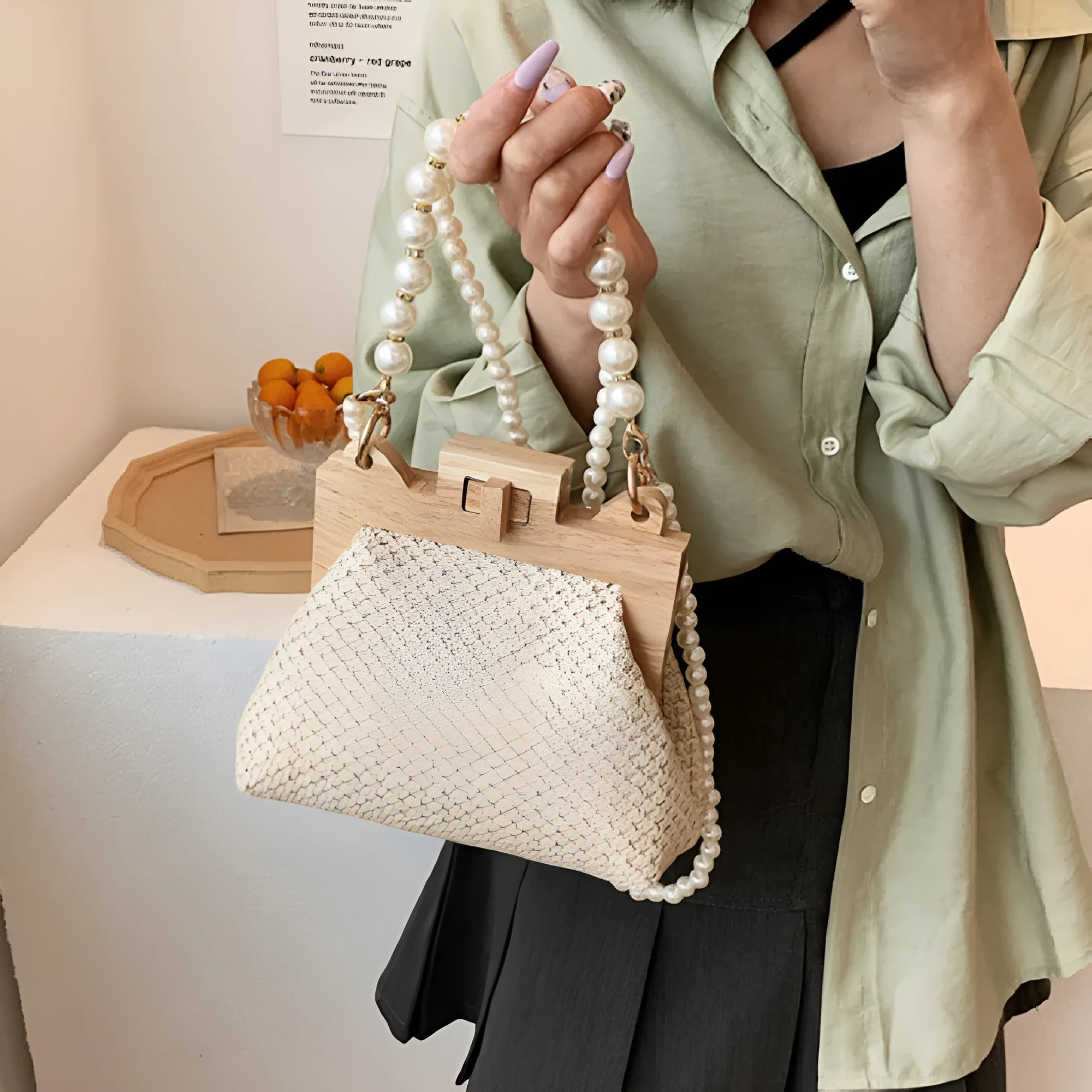 Women's woven straw shoulder bag with pearl chain detailing and multiple interior compartments