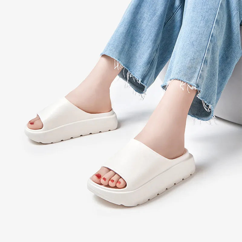 Women's beige fish mouth slippers with a thick 5.5cm light-coloured EVA sole on a wooden floor.