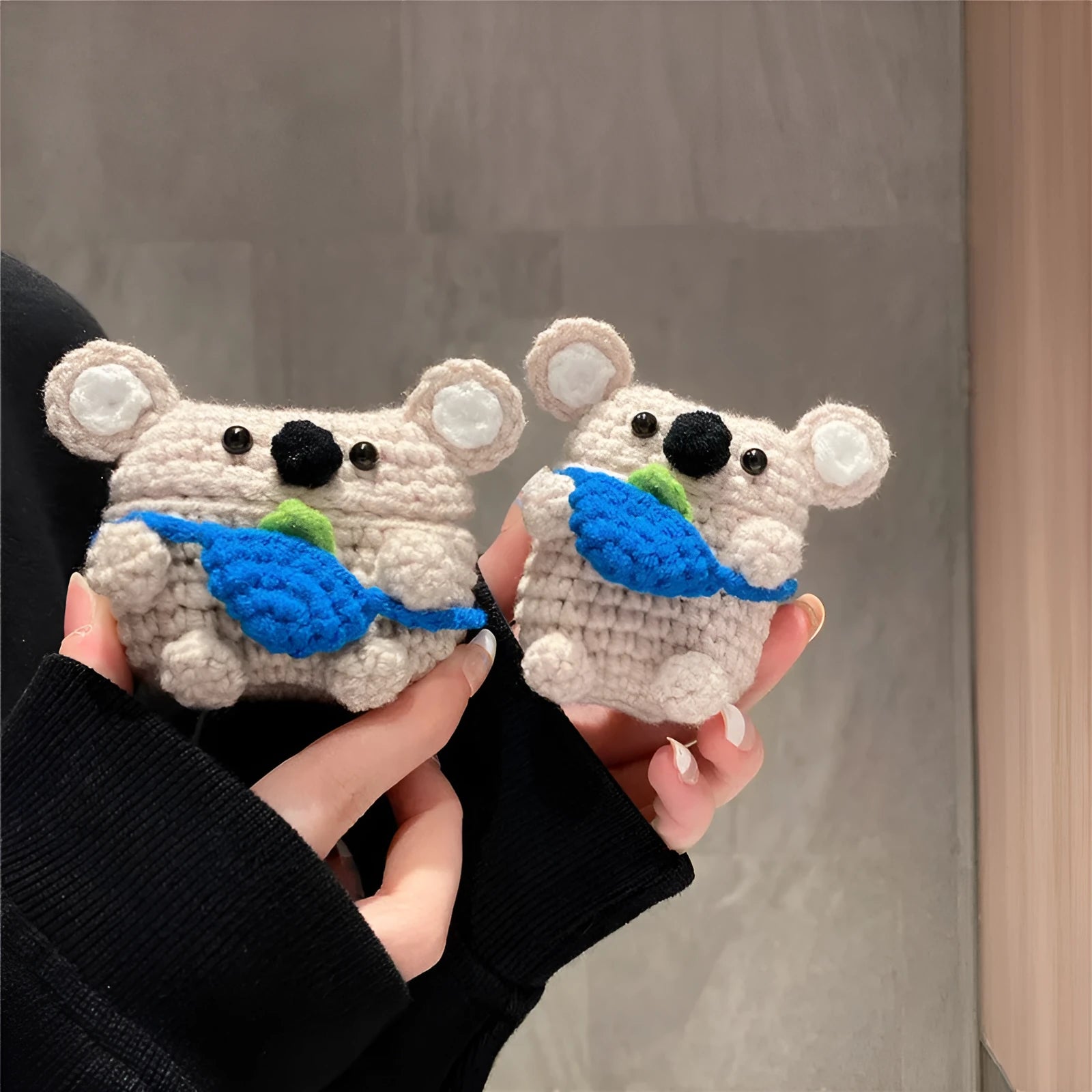 Hand-knitted koala bear backpack design cover for Apple AirPods charging case on a white background.